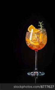 Aperol spritz cocktail in a glass with ice and orange on a black background. Aperol spritz cocktail