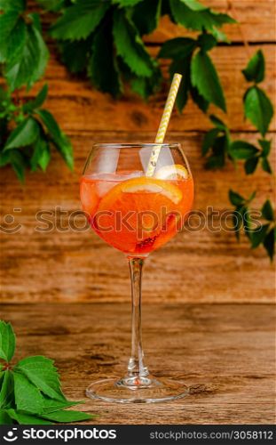 Aperol spritz cocktail with drinking straw on rustic wooden background. Vertical. Aperol spritz cocktail with drinking straw on rustic wooden background.