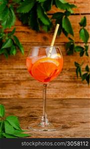 Aperol spritz cocktail with drinking straw on rustic wooden background. Vertical. Aperol spritz cocktail with drinking straw on rustic wooden background.