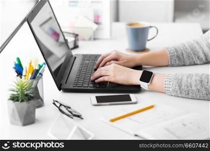 app design, technology and business concept - designer with smart watch and laptop at office. designer with smart watch and laptop at office
