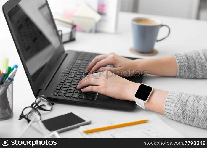 app design, technology and business concept - designer with smart watch and laptop at office. designer with smart watch and laptop at office