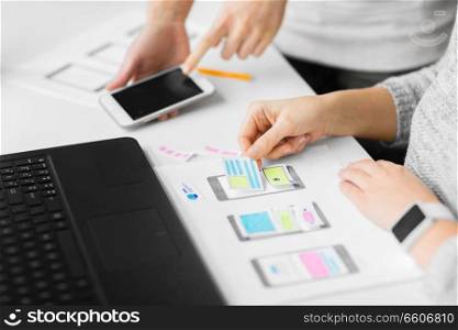 app design, technology and business concept - web designers or developers with smartphone working on user interface at office. web designers creating mobile user interface