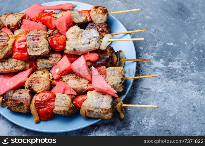 Appetizer kebab with watermelon.Grilled meat skewers, shish kebab. Shish kebab with watermelon