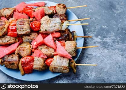 Appetizer kebab with watermelon.Grilled meat skewers, shish kebab. Shish kebab with watermelon