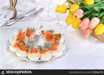 Appetizer of eggs stuffed salmon pate and yolks with salmon slices. Idea Easter table