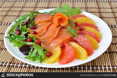 Appetizer of salmon with orange and grapefruit and a mixture of lettuce
