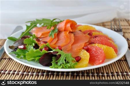 Appetizer of salmon with orange and grapefruit and a mixture of lettuce