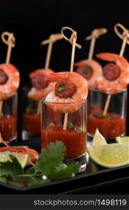 Appetizer of shish kebab with shrimps and chorizo ??sausages with barbecue sauce in a glass