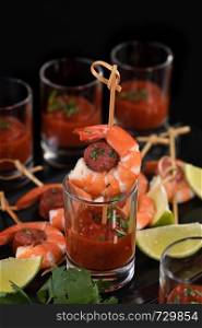 Appetizer of shish kebab with shrimps and chorizo ??sausages with barbecue sauce in a glass