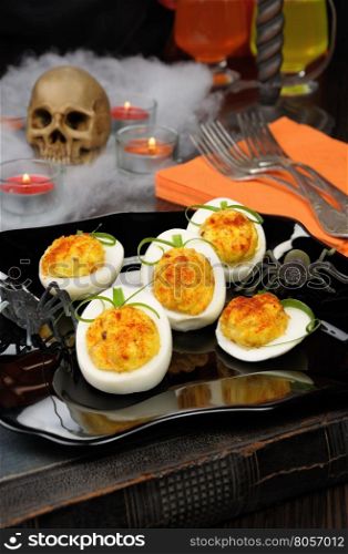 Appetizer of stuffed eggs in a pumpkin on the holiday Halloween