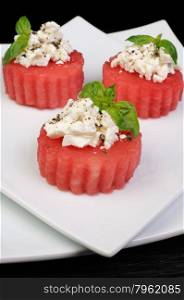 Appetizer of watermelon with ricotta and basil and spices