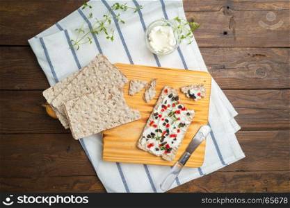Appetizer toast with cheese, red bell pepper, olives and thyme. Healthy food, vegan or diet nutrition concept on wooden table