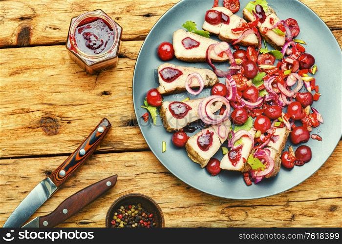 Appetizing baked pork with berry, cherry sauce for meat.. Meat with cherry sauce.