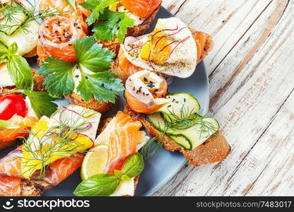 Appetizing bruschetta.Traditional italian bruschetta.Open sandwich with salmon and vegetables. Toasts with salted salmon