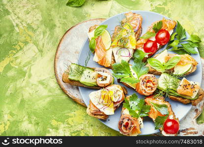 Appetizing bruschetta.Traditional italian bruschetta.Open sandwich with salmon and vegetables. Toasts with salted salmon