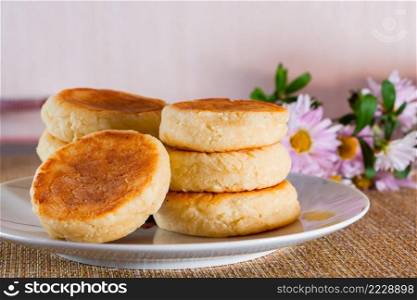 Appetizing cheesecakes on a plate on a brown background. Dish of cottage cheese for breakfast.. Cheesecakes on a plate on a brown background. Dish of cottage cheese for breakfast.
