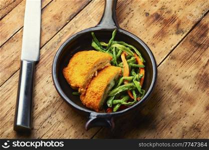 Appetizing chicken cutlet with a garnish from asparagus beans and carrots. Chicken cutlets and vegetable garnish.