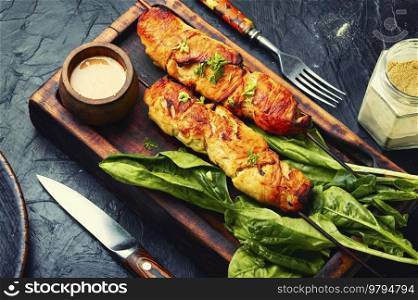 Appetizing chicken meat, chicken breast roasted on wooden skewers. Kebabs on cutting board. Chicken skewers, grilled meat
