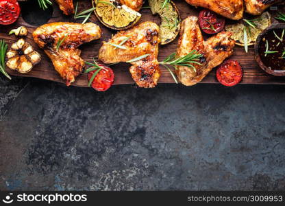 appetizing chicken wings grilled barbecue with spices and vegetables until crisp, top view, space for text. appetizing chicken wings grilled barbecue with spices and vegetables until crispappetizing chicken wings grilled barbecue with spices and vegetables until crisp, top view, space for text