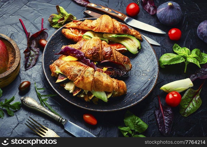 Appetizing croissants,healthy breakfast.Croissants with trout, meat bacon, vegetables and fruits. Croissants or sandwich with meat and fish