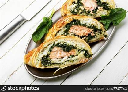 Appetizing fish pie made from salmon fish, rice and spinach. Red fish pie.. Salmon baked in dough.