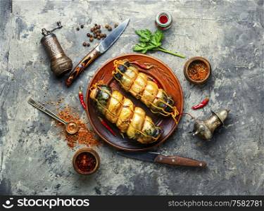 Appetizing fish roll made from smoked mackerel.Hot smoked fish.. Plate with smoked fish
