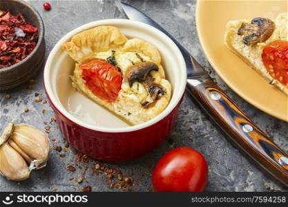 Appetizing garlic tart with tomato,mushrooms and feta cheese. Tart with tomato and mushrooms