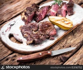 Appetizing grilled meat. Sliced meat steak on the kitchen board