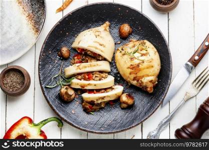 Appetizing grilled squids with vegetable stuffing. Roasted stuffed squid. Mediterranean dish, top view. Grilled squid with vegetables, stuffed calamari.