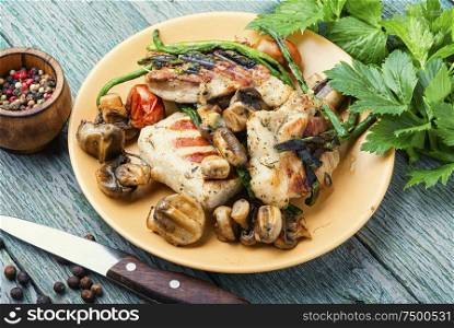 Appetizing grilled steak with mushrooms and herbs on a plate. Grilled meat on rustic wooden table