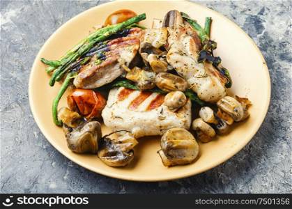Appetizing grilled steak with mushrooms and herbs on a plate. Delicious grilled meat