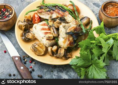 Appetizing grilled steak with mushrooms and herbs on a plate. Grilled meat with mushrooms