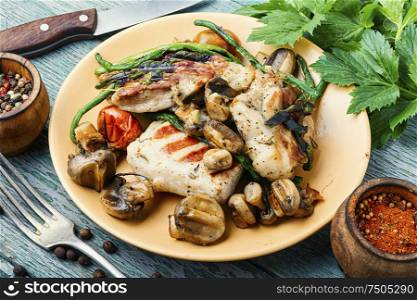 Appetizing grilled steak with mushrooms and herbs on a plate. Grilled steak and spices