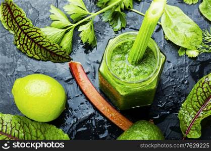 Appetizing healthy summer green smoothie from stalks of rhubarb and herbs.. Rhubarb and greens smoothie