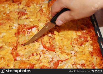 appetizing home pizza cutting by knife. cook cuts appetizing home pizza by knife