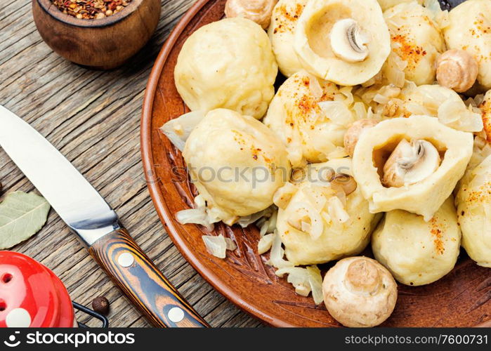 Appetizing homemade dumplings with mushroom filling on old wooden table. Homemade varenyky with mushrooms.