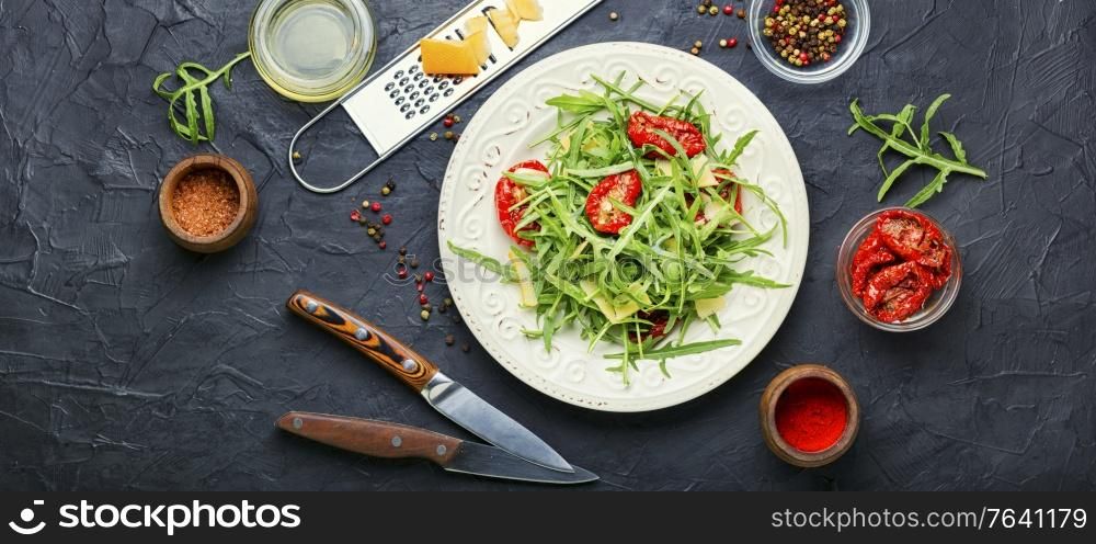Appetizing Italian salad with arugula, sun-dried tomatoes and cheese.Summer salad. Green salad with sun dried tomato