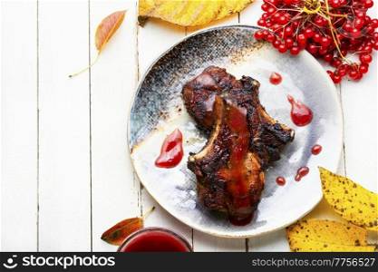Appetizing meat on the bone baked with viburnum syrup.Meat food. Grilled pork with viburnum
