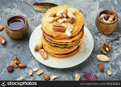 Appetizing pancakes with nuts and maple syrup. Pancakes with maple syrup.
