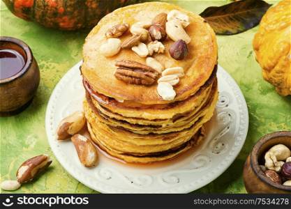 Appetizing pancakes with nuts and maple syrup. Pancakes with maple syrup.