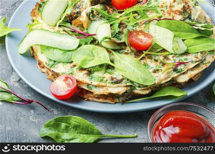 Appetizing pancakes with spinach and arugula.Pancakes with herbs on a plate. Homemade pancakes with herbs