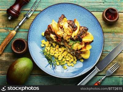 Appetizing pork meat baked with mango and cheese. Baked meat with mango