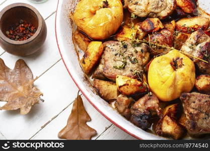 Appetizing pork stew with quince in tray. Autumn recipe. Pork cooked with autumn quince.