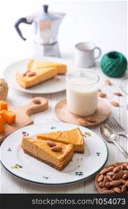 appetizing pumpkin cheesecake and glass of milk, almonds