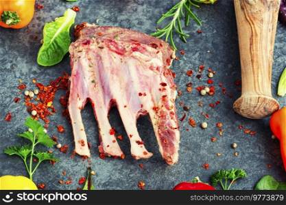 Appetizing raw lamb rib and spices on the kitchen table.. Raw fresh lamb ribs.