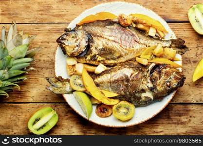 Appetizing river carp baked with fruits. Grilled fish. Baked carp with fruit.