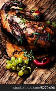 Appetizing roasted duck. roasted duck with grapes on the kitchen cutting board