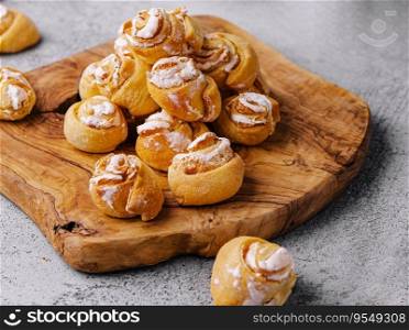 Appetizing ruddy buns-roses on wood close up