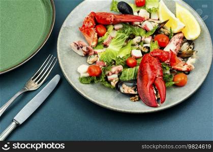 Appetizing salad of oysters, mussels, lobster and vegetables. Healthy food.. Yummy seafood salad on a plate