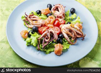 Appetizing salad with calamari, salmon and vegetables.. Salad squid with green and seafood